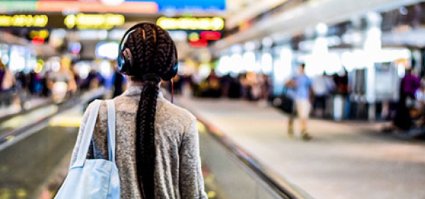 写真：背を向け街を歩く若い女性